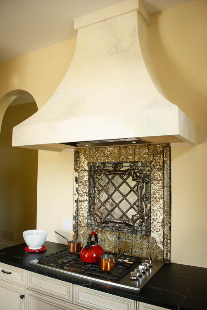 custom stove top with custom tin back splash and hood fan